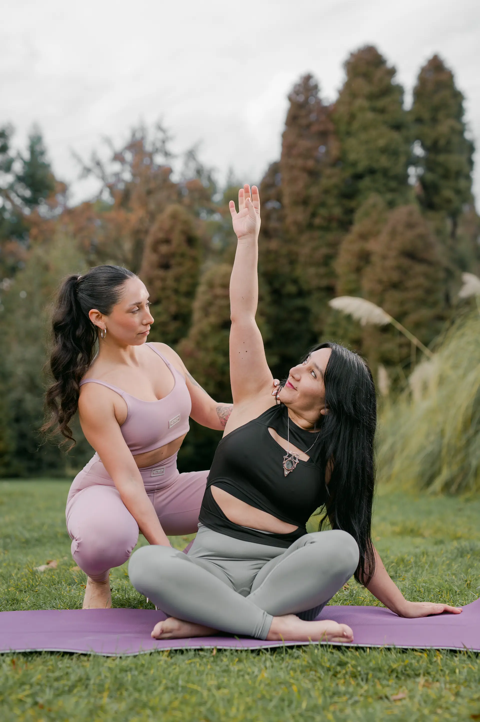 Tamara ajustando a una alumna durante una clase de yoga en ARUNA